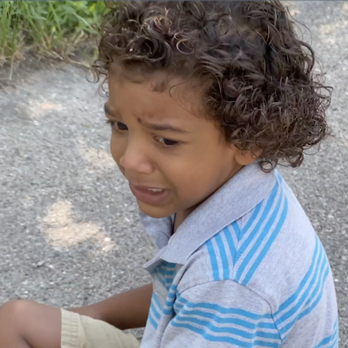 Boy in blue and white stripe t-shirt crying