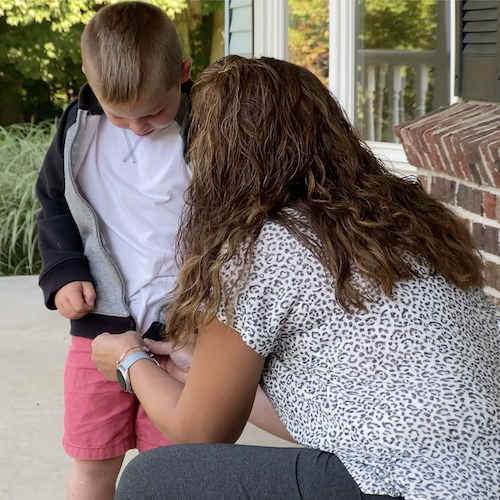 A BuildUp coordinator zipping a boy's zipper sweatshirt